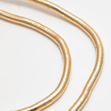 Cargar imagen en el visor de la galería, Primer plano de dos brillantes cadenas multiuso moldeables Collar de oro fabricadas en acero inoxidable, expuestas sobre una superficie blanca con sutiles curvas y un diseño texturizado y segmentado estilo serpiente.