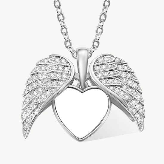 Collar personalizado con foto en forma de corazón, color platino, con dije corazón rodeado por dos alas de ángel decoradas con piedras brillantes. La delicada cadena se une en la parte superior del collar para un toque elegante.