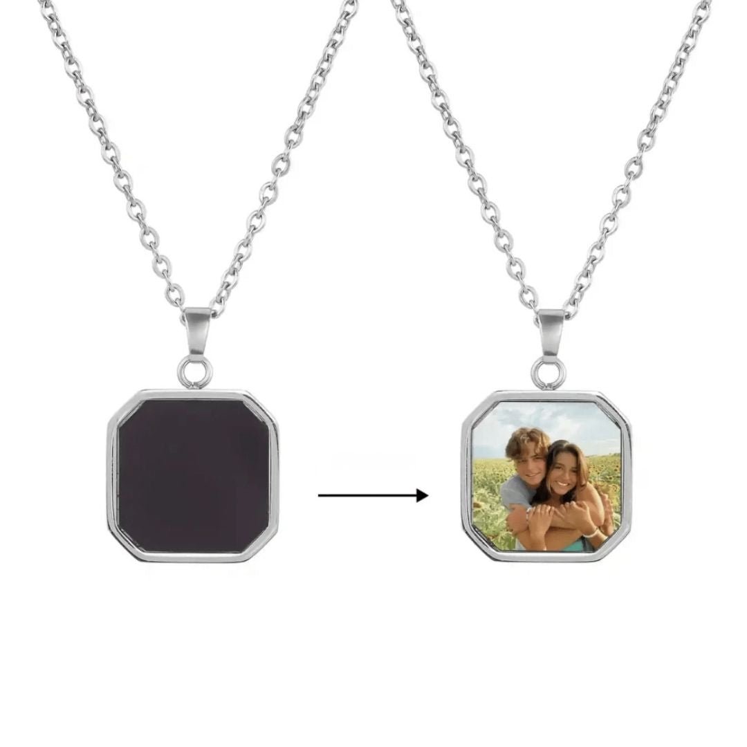 Dos collares de plata se exhiben uno al lado del otro; el colgante de la izquierda es liso y oscuro, mientras que el de la derecha muestra un Collar personalizado con foto secreta que revela una foto al aire libre de una pareja sonriente, con una flecha que apunta de izquierda a derecha.