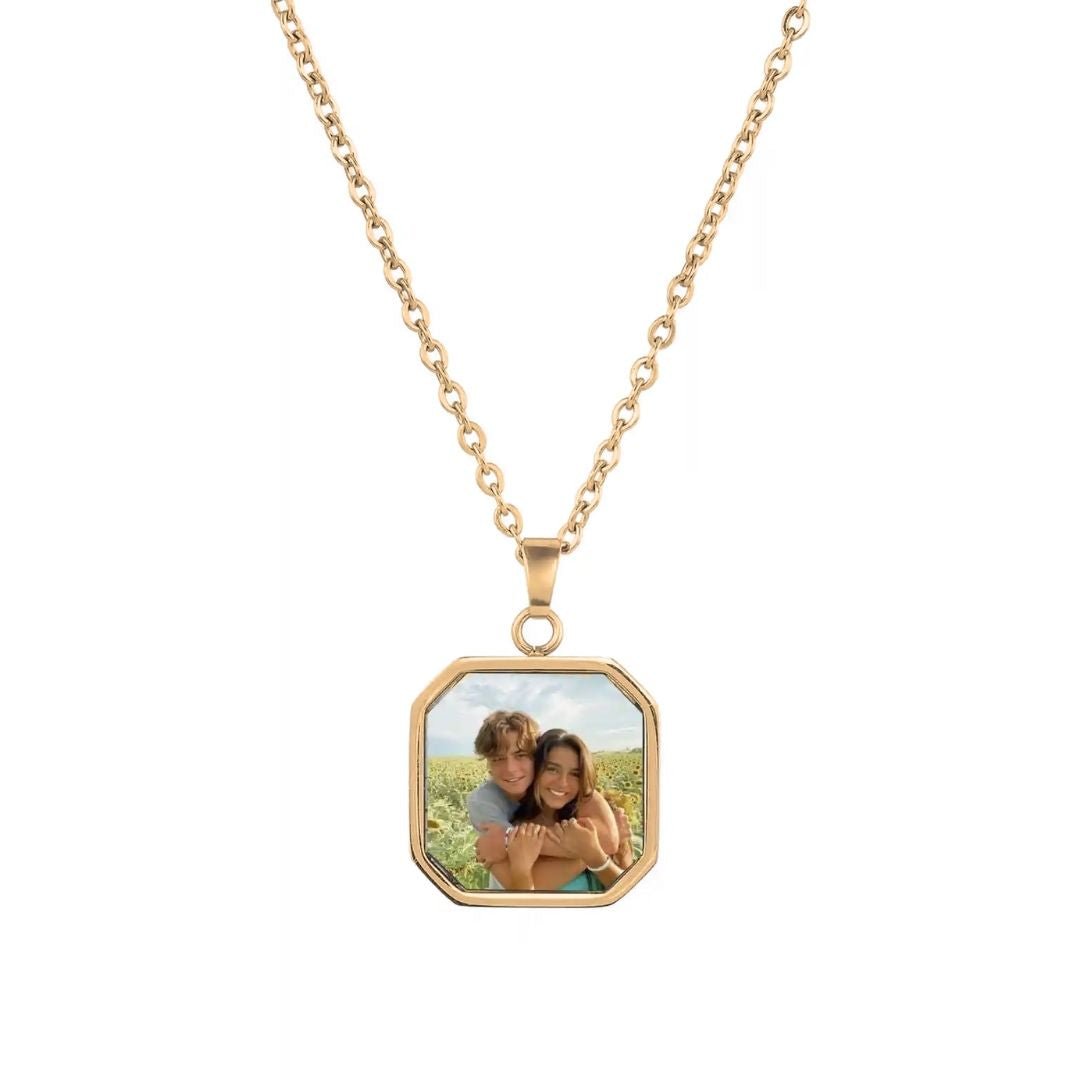 El Collar personalizado con foto secreta en color dorado incluye un dije cuadrado con la imagen de una pareja sonriente abrazándose en un campo soleado. Es el regalo personalizado ideal para alguien especial.