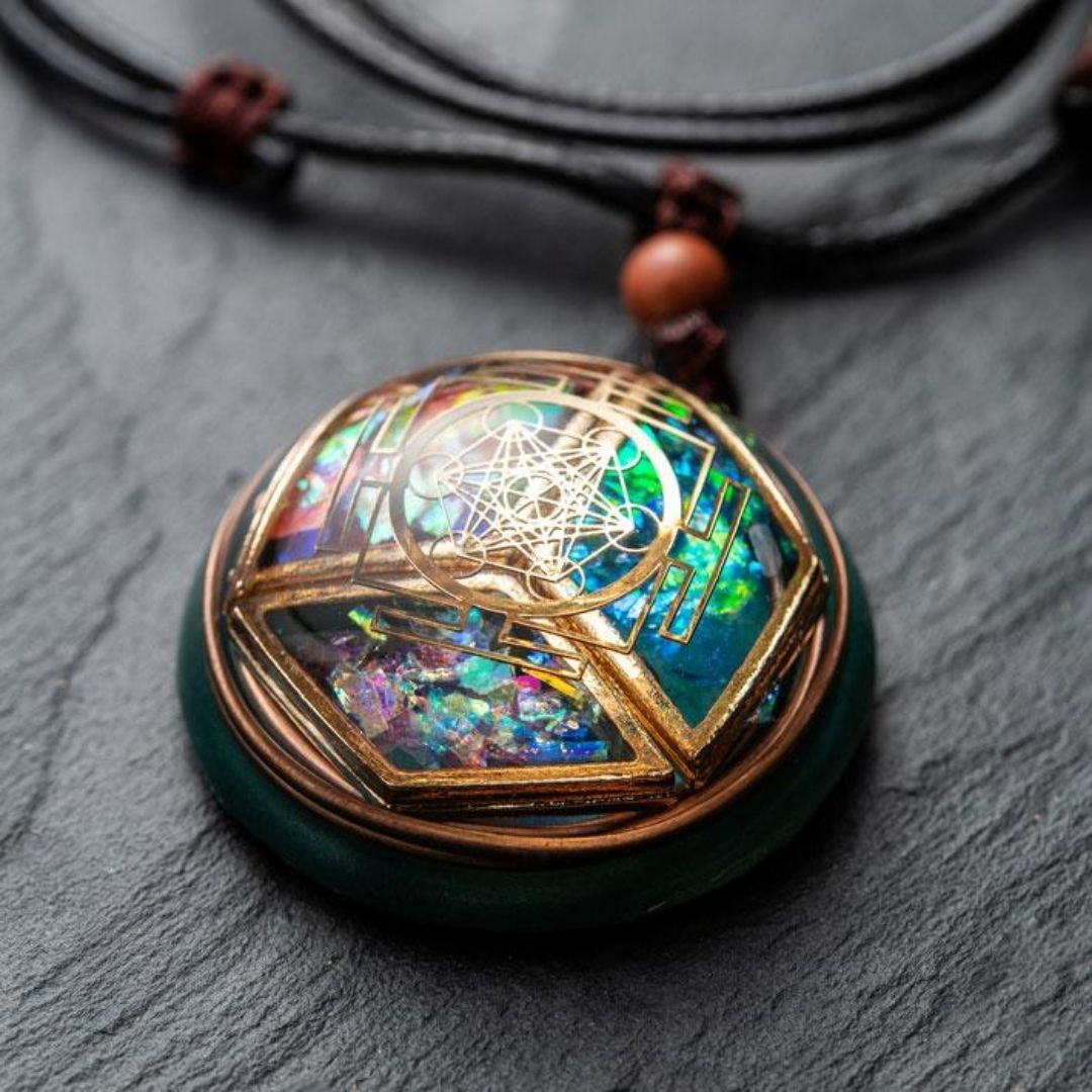 Primer plano del collar Talismán energético con geometría sagrada: presenta una colorida piedra iridiscente con alambre geométrico dorado, cordón negro, cuentas de madera y oscuras, perfecto para el equilibrio interior, expuesto sobre un fondo de textura oscura.
