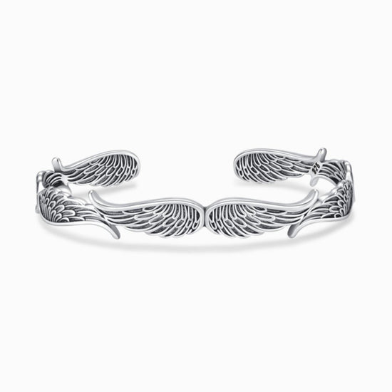 Inspirada en la Pulsera Alas de ángel, esta pulsera brazalete de plata presenta alas emplumadas finamente detalladas en cada extremo y un diseño abierto y ajustable, lo que la convierte en un significativo regalo Abrazo del Cielo.