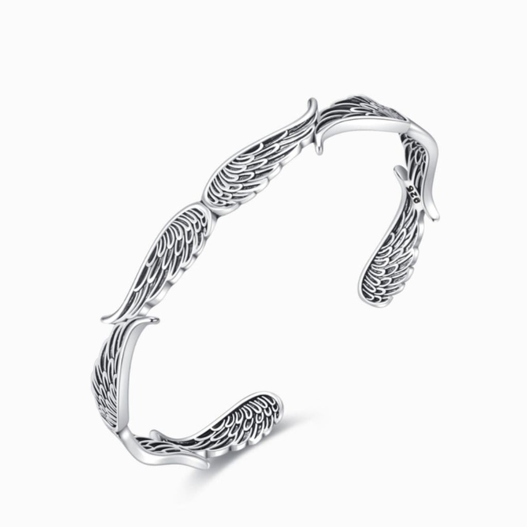 La Pulsera Alas de ángel es una pulsera brazalete de plata con detallados dibujos de alas de ángel, con un acabado pulido y abierto: un elegante y delicado regalo Abrazo del Cielo para sus seres queridos.