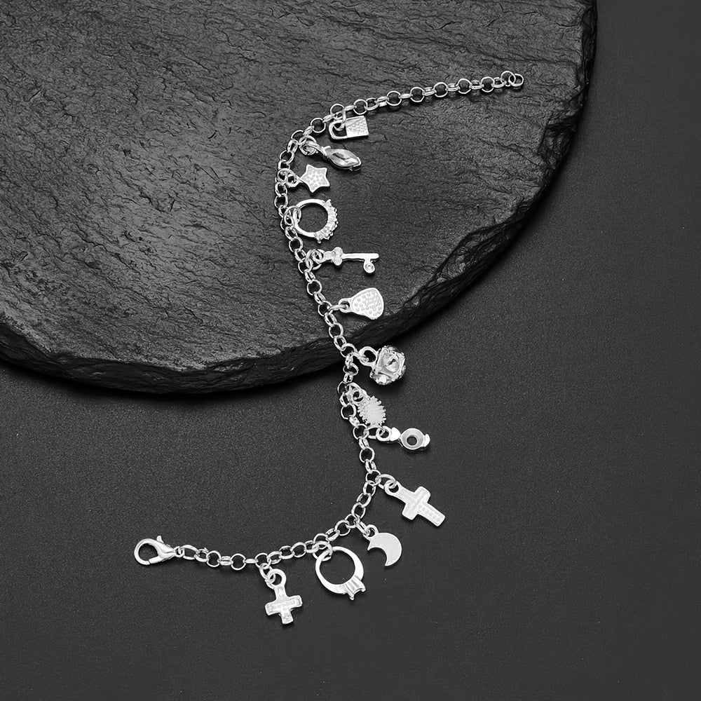 La Pulsera con 13 amuletos (2x1 limitado) incluye corazones, estrellas, una cruz, una llave y una luna creciente en plata 925 sobre una superficie de piedra negra texturizada, ideal para atraer energía positiva a tu vida diaria.