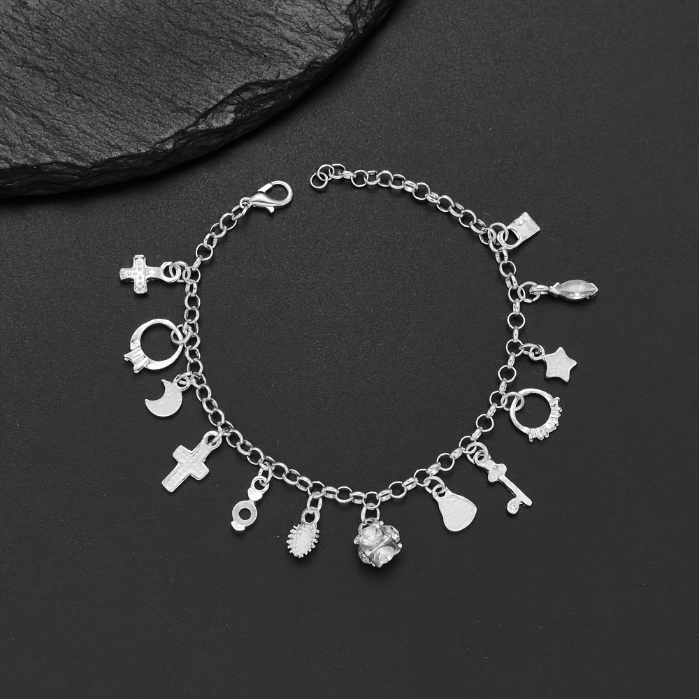 Pulsera con 13 amuletos (2x1 limitado) de plata 925: cruz, luna, corazón, cactus y más; desborda energía positiva. Exhibida sobre fondo negro junto a una piedra texturizada.