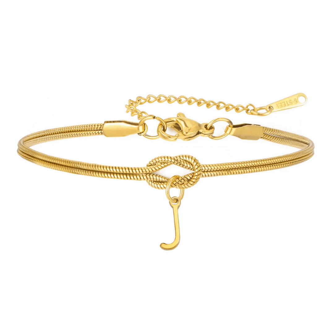 La Pulsera de nudo con inicial es una pulsera dorada con cadena tipo serpiente, detalle de nudo central, gancho y extensión ajustable. Ideal como pulsera personalizada para un regalo inolvidable.
