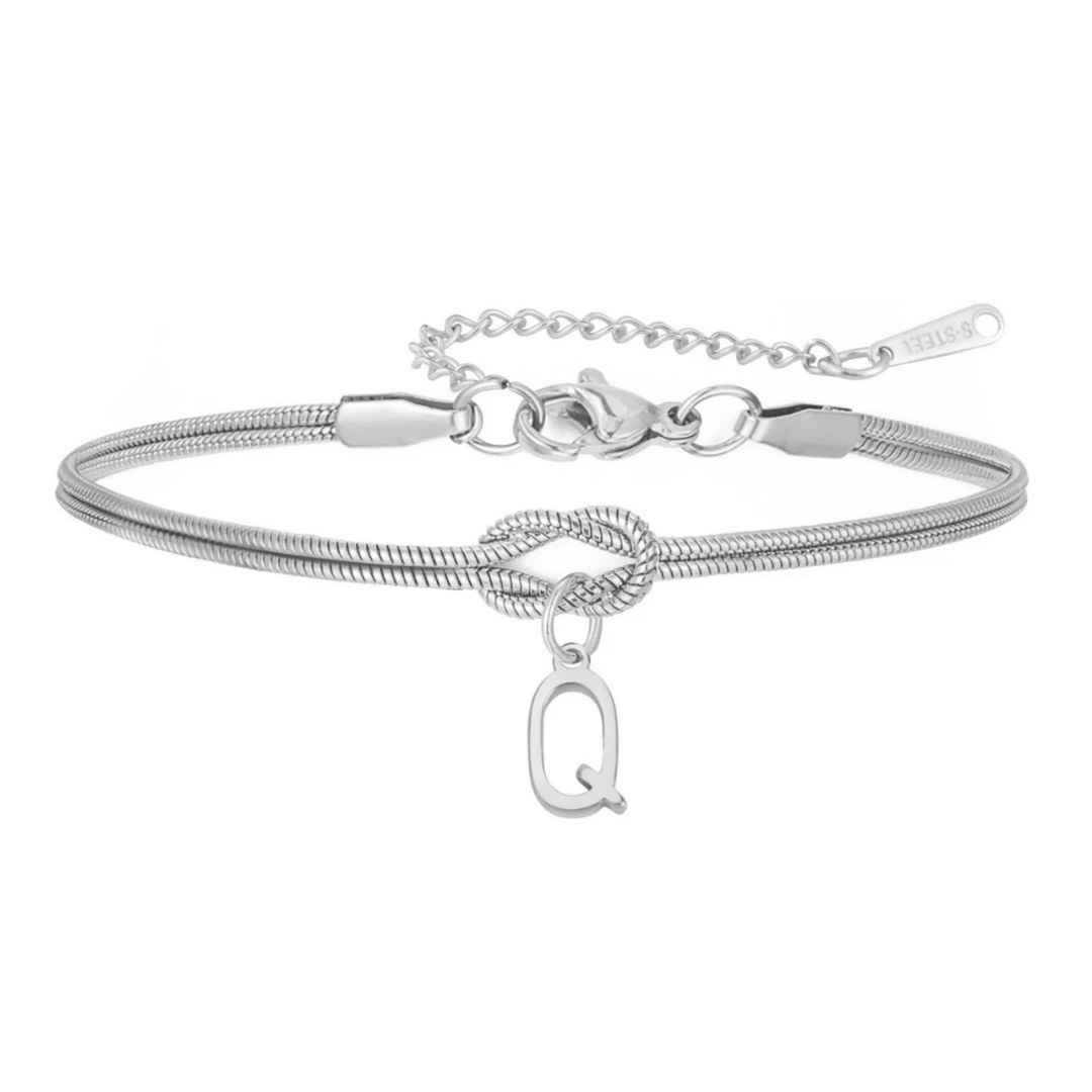 Pulsera de nudo con inicial: elegante pulsera plateada con cadena tipo snake, detalle de nudo y dije "Q". Su cierre ajustable y etiqueta "SIL." la convierten en un regalo inolvidable y la pulsera personalizada ideal para cualquier ocasión especial.