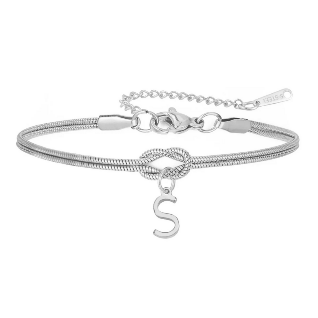 La Pulsera de nudo con inicial en plata cuenta con un detalle de nudo central, dije colgante con letra S y cierre de langosta ajustable con cadena de extensión-ideal como un regalo inolvidable.