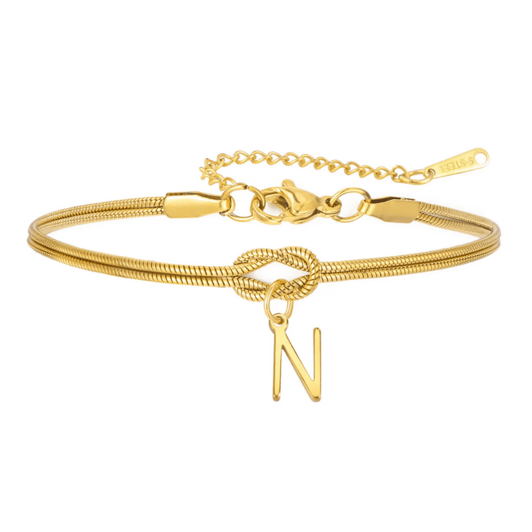 La Pulsera de nudo con inicial es una pulsera de oro personalizada con cadena de serpiente, cierre de langosta, ajuste regulable y un colgante con la letra N, lo que la convierte en un regalo inolvidable.