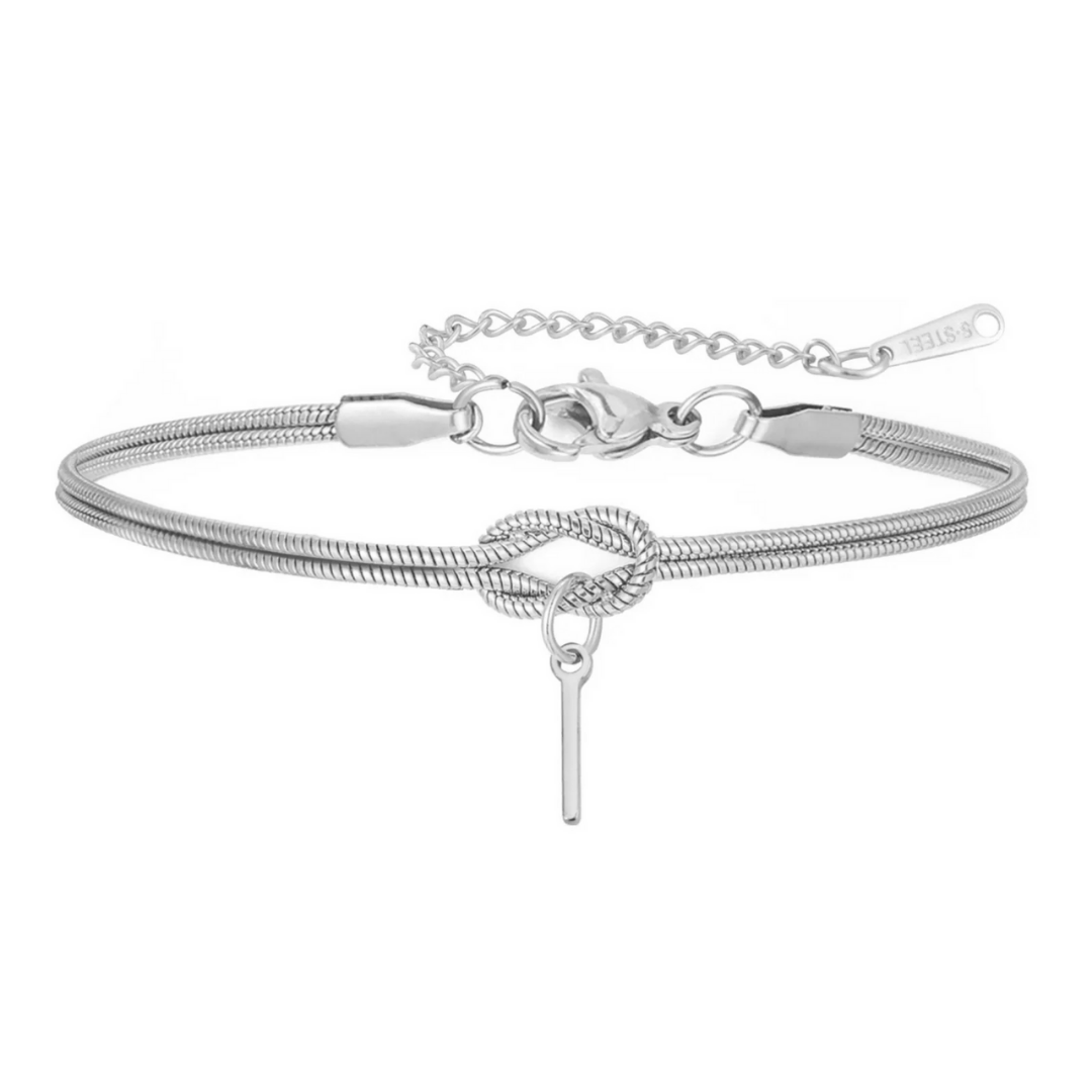 La Pulsera de nudo con inicial es una delicada pulsera de plata con cadena tipo serpiente, detalle central de nudo, barra fina colgante y cierre ajustable-un regalo inolvidable para cualquier ocasión.