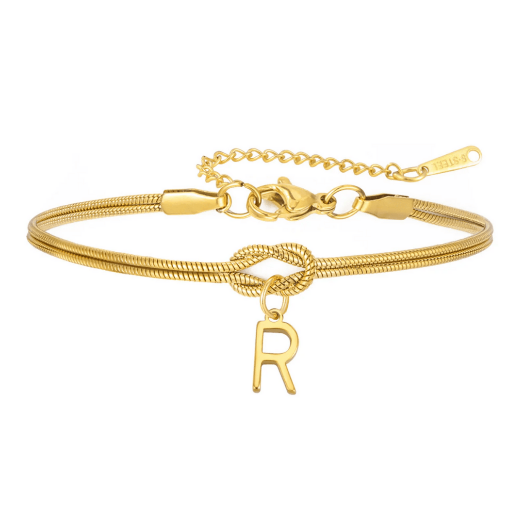 A Pulsera de nudo con inicial en dorado, con una fina cadena, charm de letra R colgante y cierre ajustable-el regalo perfecto e inolvidable para alguien especial.