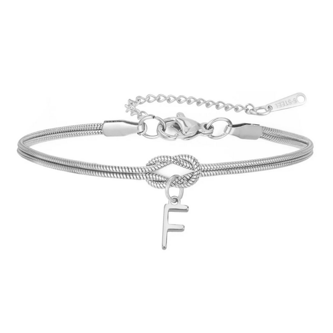 La Pulsera de nudo con inicial es una pulsera de cadena plateada con broche ajustable, detalle de nudo central y dije colgante con la letra F-un regalo inolvidable y personalizado.