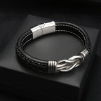 Pulsera con nudo infinito personalizable - A mi hijo: diseño de cuero negro con costuras blancas, cierre magnético plateado y nudo decorativo en plata, presentada en caja negra. Un regalo elegante y significativo para tu hijo.