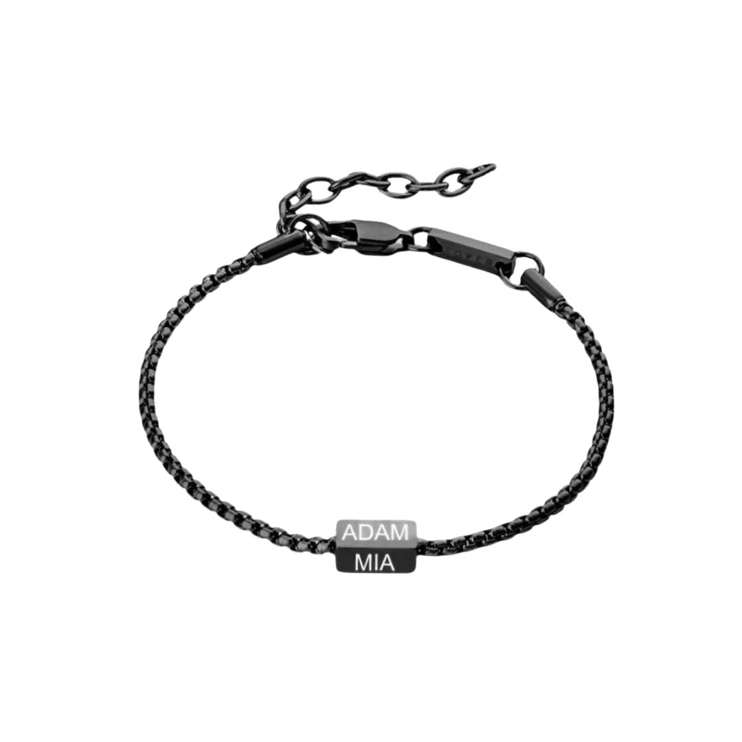 La Pulsera de cubo personalizada, en acero inoxidable negro con placa rectangular grabada ADAM y MIA en blanco. Cierre ajustable. Un regalo ideal para papá en el Día del Padre.