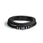 La Pulsera de cuero - Al hombre de mi vida tiene tres bandas de cuero negro trenzado con una pieza central decorativa plateada, negra y dorada y un cierre magnético negro, perfecta como regalo de amor o pulsera personalizada para cualquier ocasión.