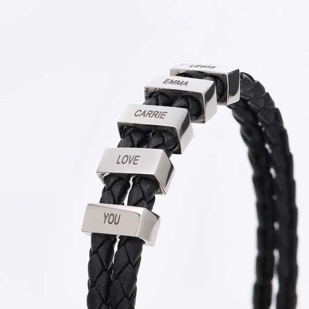 Pulsera de cuero para Papá en negro, personalizada con cinco cuentas rectangulares de plata grabadas con los nombres LEWIS, EMMA, CARRIE, LOVE y YOU. Fondo blanco; un regalo ideal para hombre.