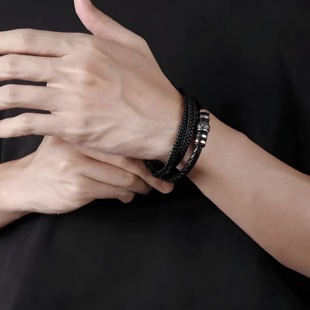 Una persona luce la Pulsera de cuero - Siempre contigo Papá, con detalles metálicos sobre fondo negro. Es un elegante accesorio masculino, perfecto como regalo para padres o para sorprender a papá en cualquier ocasión especial.