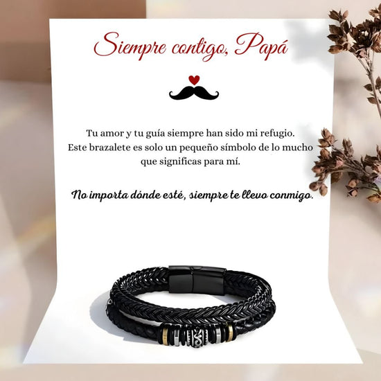 Detrás de la Pulsera de cuero - Siempre contigo Papá, aparece una tarjeta con el mensaje "Siempre contigo, Papá" y una sentida nota para papá. Las flores secas de la derecha añaden un toque de consideración a este regalo para padres.