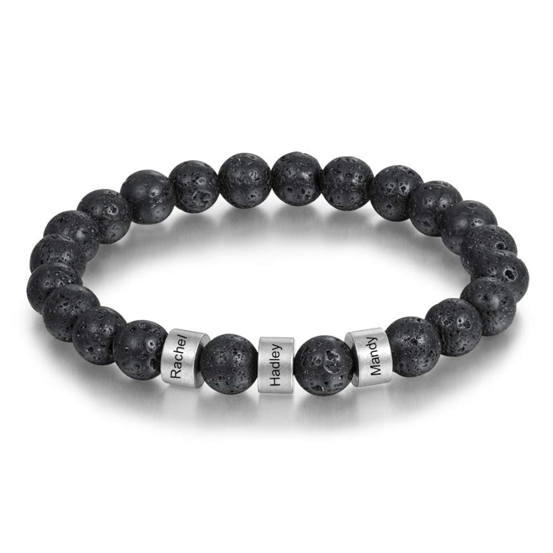 La Pulsera de piedra volcánica personalizada lleva cuentas negras y tres cuentas plateadas grabadas con los nombres Rachel, Hailey y Mandy; es el regalo perfecto para el día del padre.