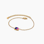Pulsera dos mitades con piedras de nacimiento: elegante cadena dorada con dos gemas, una azul y una rosa, en el centro. Incluye cierre tipo langosta y cadena ajustable, ideal como joya personalizada para cualquier ocasión.
