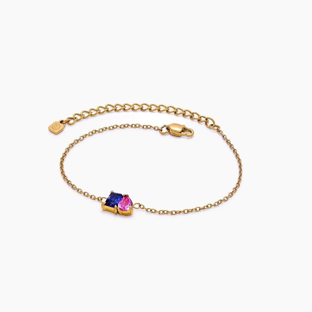 Pulsera dos mitades con piedras de nacimiento: elegante cadena dorada con dos gemas, una azul y una rosa, en el centro. Incluye cierre tipo langosta y cadena ajustable, ideal como joya personalizada para cualquier ocasión.