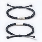 Dos pulseras negras "El mejor Papá" con nudos ajustables sobre fondo blanco: una lleva cuatro cuentas plateadas grabadas con caras de dibujos animados y "Tiempos tristes", mientras que la otra lleva cuentas plateadas lisas. Ambas son totalmente personalizables.