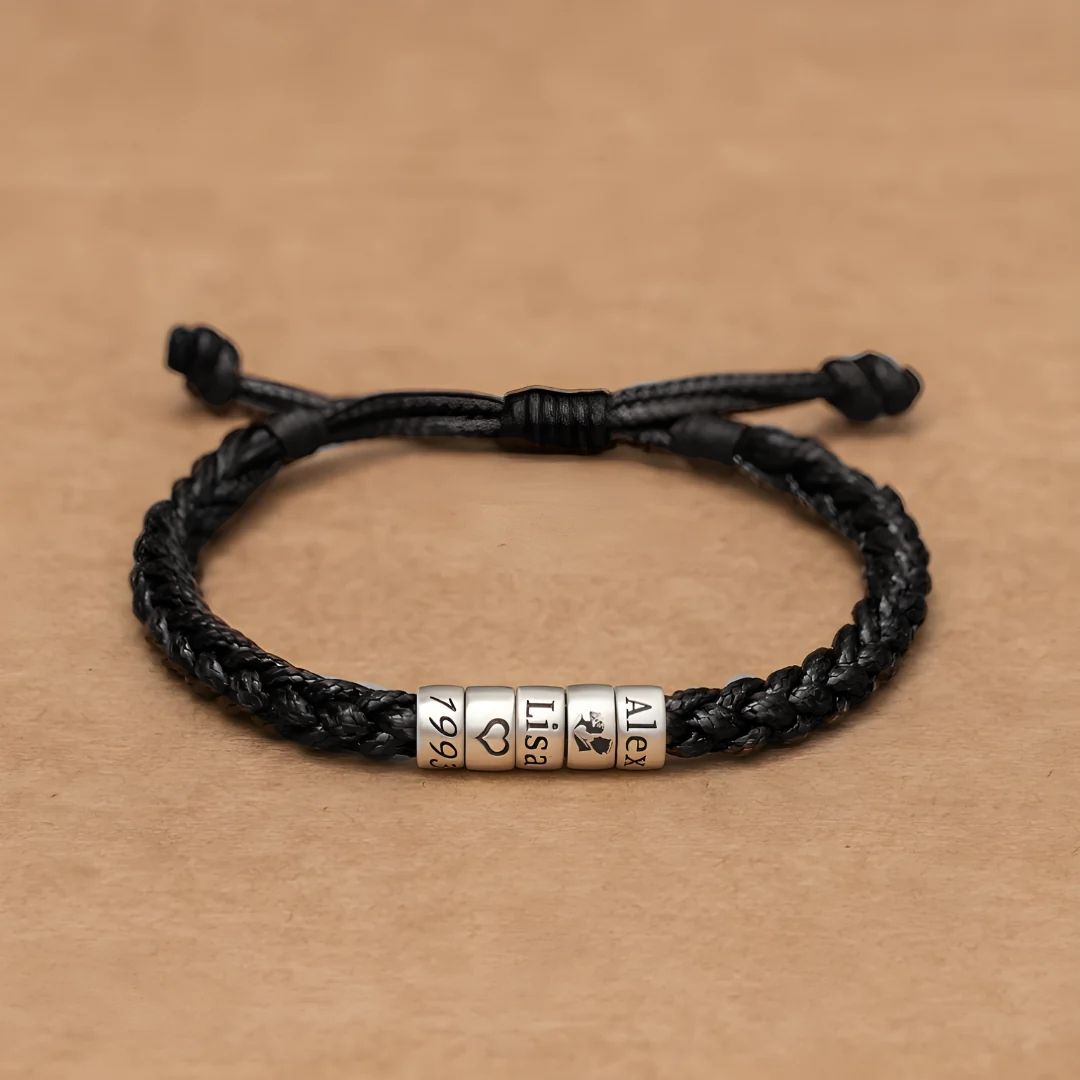 La Pulsera "El mejor Papá" - Personalizable lleva un cordón trenzado negro con cuatro cuentas plateadas grabadas con 1996, un corazón, Lisa y Alex, perfecta como pulsera personalizada papá o regalo día del padre.