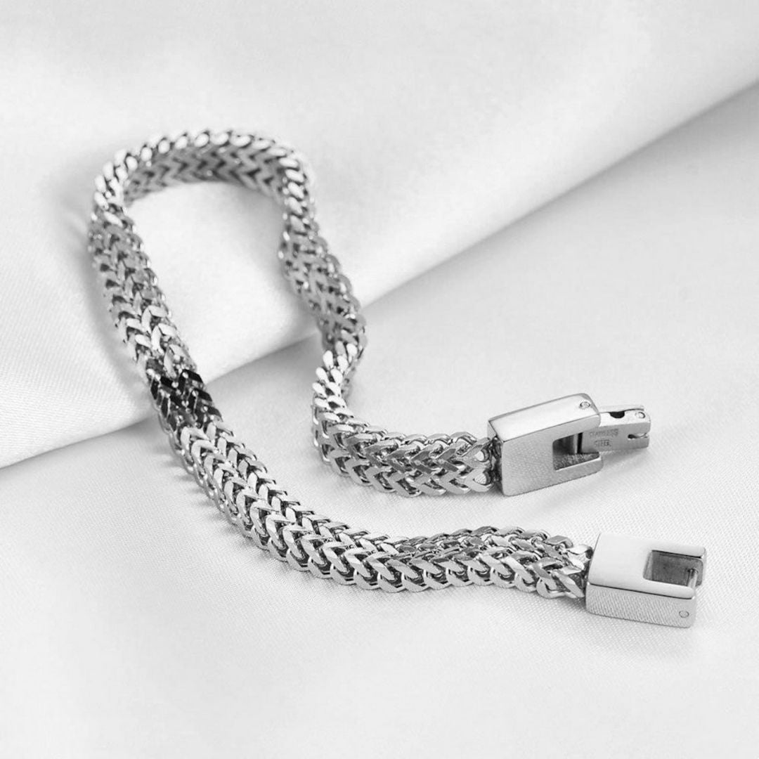 La Pulsera grabada - A mi amor presenta una cadena de plata pulida con un apretado diseño entrelazado y un elegante cierre rectangular, elegantemente expuesta sobre tela blanca, perfecta como regalo para él.
