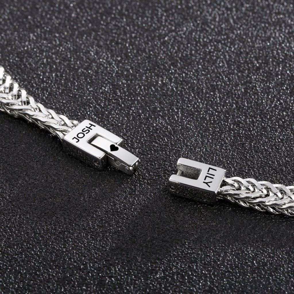 Un primer plano de la Pulsera grabada - A mi amor, una pulsera de plata personalizada con cierres etiquetados JOSH y LILY, desplegada sobre negro texturizado-un regalo ideal para hombre.