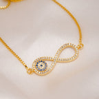 La Pulsera Infinito con ojo turco (OFERTA 2X1) presenta un símbolo de infinito con piedras brillantes y un círculo de piedras azules y claras que se asemeja al ojo turco, como protección contra la energía negativa. Se presenta en un tejido suave y pálido.