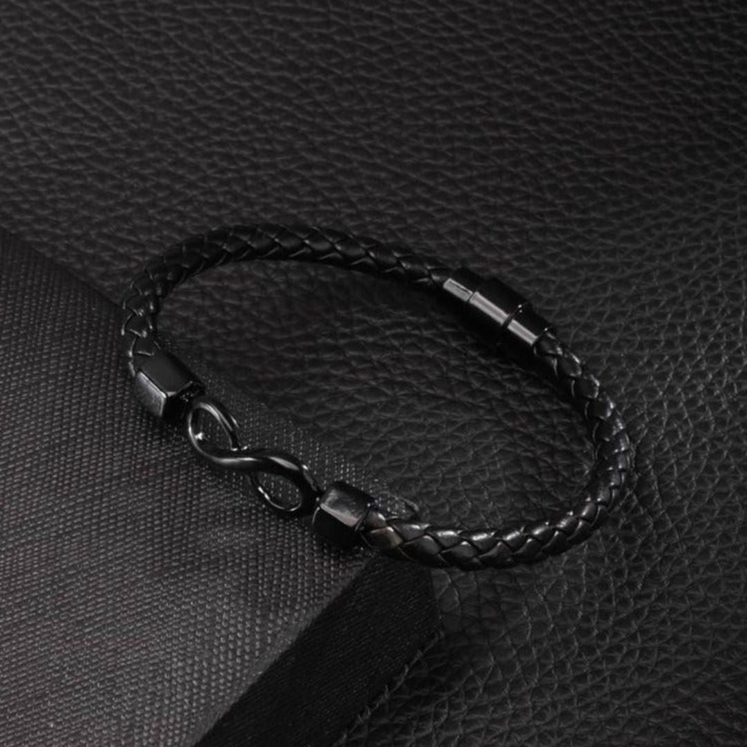 La Pulsera Infinito personalizada - A mi Hombre es una pulsera de cuero trenzado negro con un cierre metálico con el símbolo del infinito, lo que la convierte en la pulsera de cuero grabada perfecta y en un regalo ideal para hombre.
