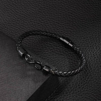 La Pulsera Infinito personalizada - A mi Hombre es una pulsera de cuero trenzado negro con un cierre metálico con el símbolo del infinito, lo que la convierte en la pulsera de cuero grabada perfecta y en un regalo ideal para hombre.
