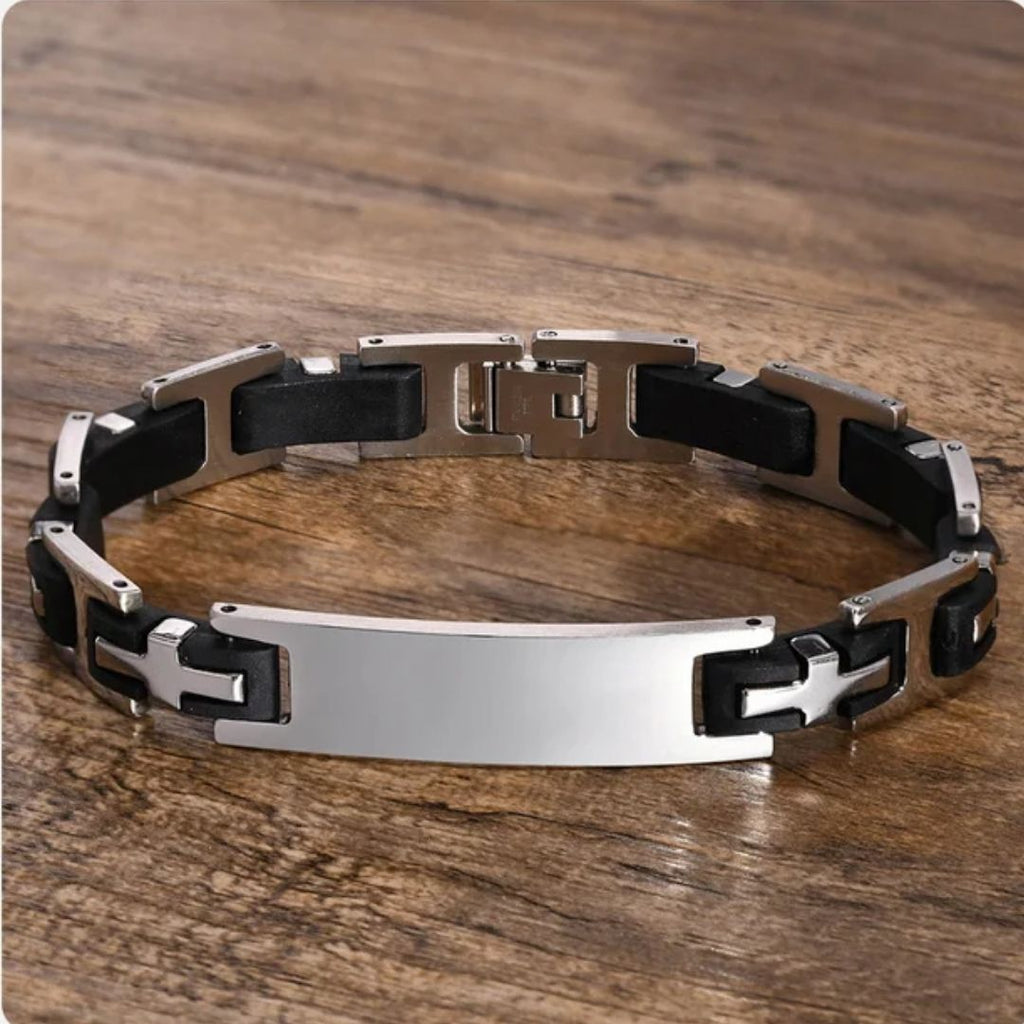 Pulsera personalizada con frase para hombre, hecha de eslabones de acero inoxidable negro y plateado y placa central brillante, exhibida sobre madera. Un regalo ideal para hombres con estilo.