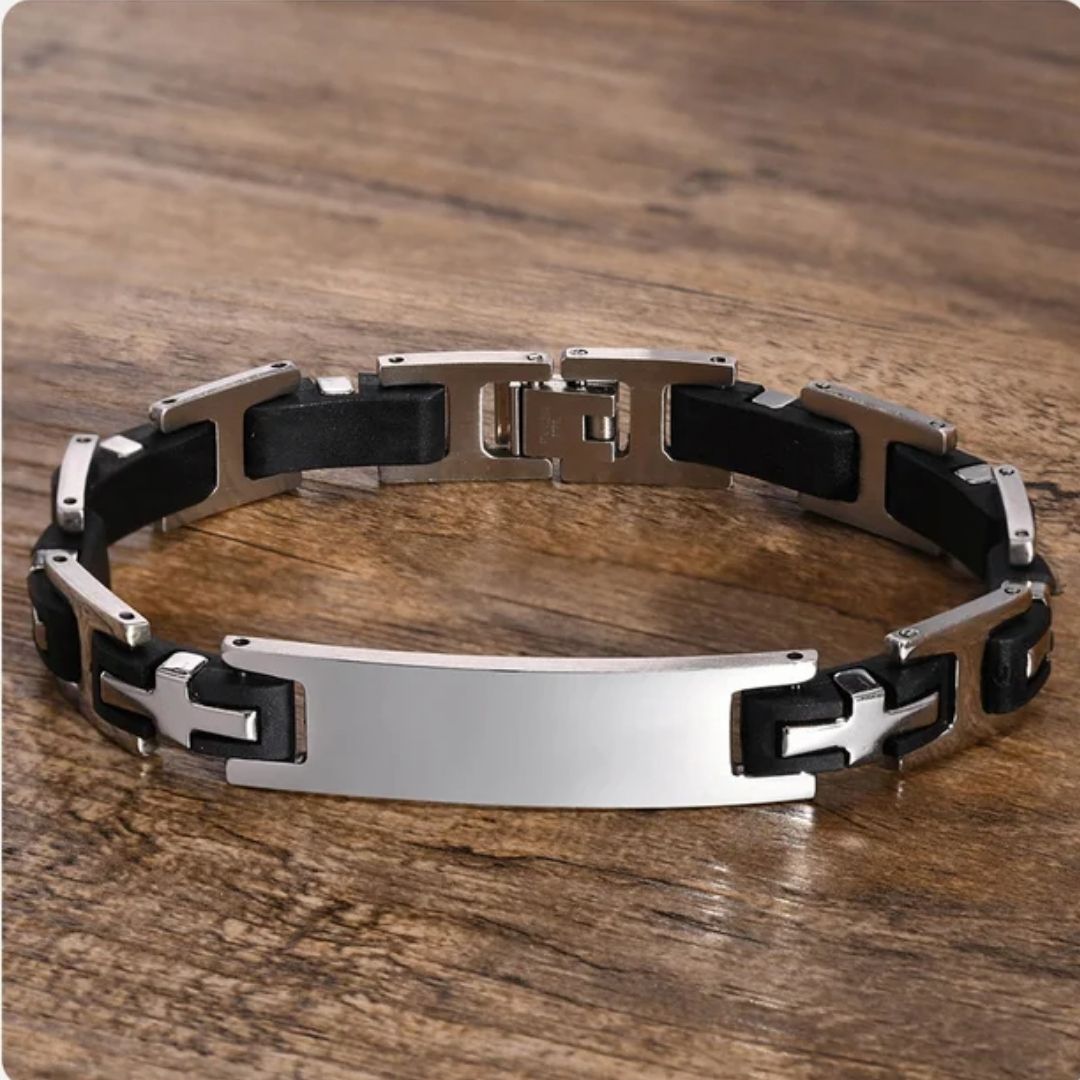 Pulsera personalizada con frase para hombre, hecha de eslabones de acero inoxidable negro y plateado y placa central brillante, exhibida sobre madera. Un regalo ideal para hombres con estilo.