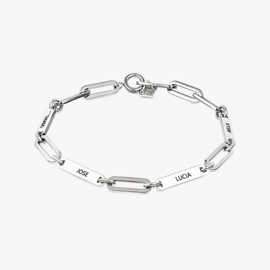 Pulsera personalizada con nombres en plata, con placas de nombre rectangulares con JOSE, LUCIA, HELEN y OSCAR grabadas uniformemente a su alrededor. Se muestra sobre fondo blanco: un regalo ideal para mamá.