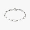 Pulsera personalizada con nombres en plata, con placas de nombre rectangulares con JOSE, LUCIA, HELEN y OSCAR grabadas uniformemente a su alrededor. Se muestra sobre fondo blanco: un regalo ideal para mamá.