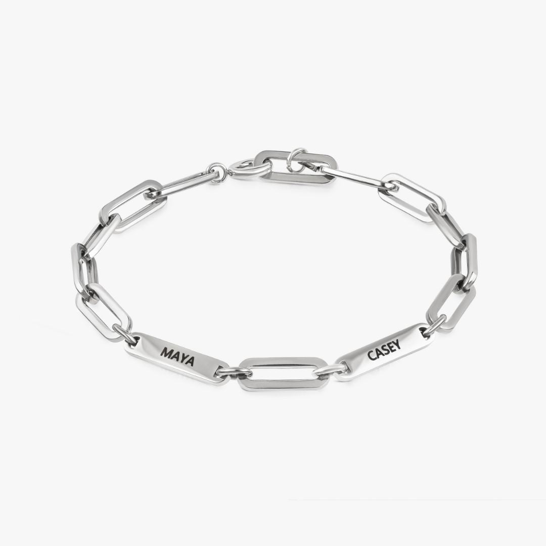 Pulsera personalizada con nombres plateados, con placas rectangulares grabadas MAYA y CASEY, sobre fondo blanco-regalo ideal para mamá.