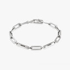 Pulsera personalizada con nombres plateados, con placas rectangulares grabadas MAYA y CASEY, sobre fondo blanco-regalo ideal para mamá.