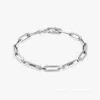 Pulsera personalizada con nombres plateados, con placas rectangulares grabadas MAYA y CASEY, sobre fondo blanco-regalo ideal para mamá.