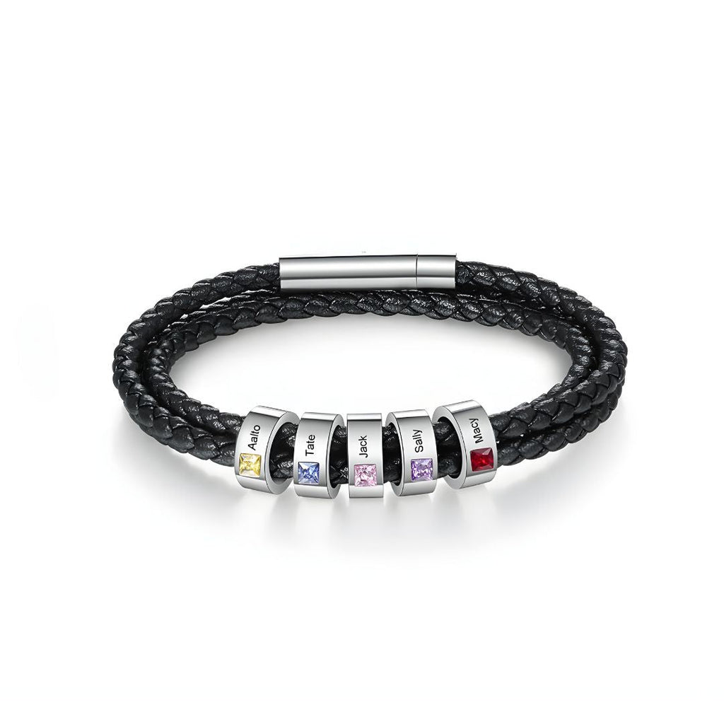 La Pulsera Piedras de vida - A mi Padre es una pulsera negra de cuero trenzado con seis cuentas de plata, cada una con piedra de nacimiento y nombre grabado. Un regalo ideal para el Día del Padre, rematada con un elegante broche plateado.