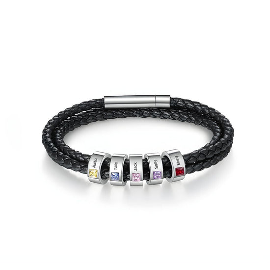 La Pulsera Piedras de vida - A mi Padre es una pulsera negra de cuero trenzado con seis cuentas de plata, cada una con piedra de nacimiento y nombre grabado. Un regalo ideal para el Día del Padre, rematada con un elegante broche plateado.