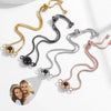 La Pulsera Recuerdo eterno se presenta en oro, negro, plata y oro rosa con una cadena ajustable y un colgante central. Cada pulsera puede mostrar una foto oculta, lo que la convierte en el regalo personalizado ideal para su ser querido.