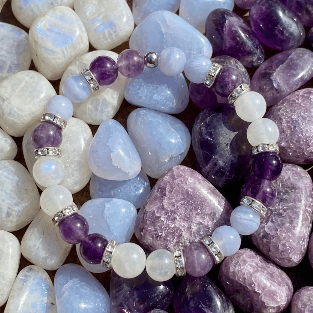 La Pulsera Serena - Alivio natural para la menopausia presenta una alternancia de piedras naturales moradas y blancas con espaciadores plateados, sobre piedras pulidas. Ideal para apoyar el equilibrio hormonal.