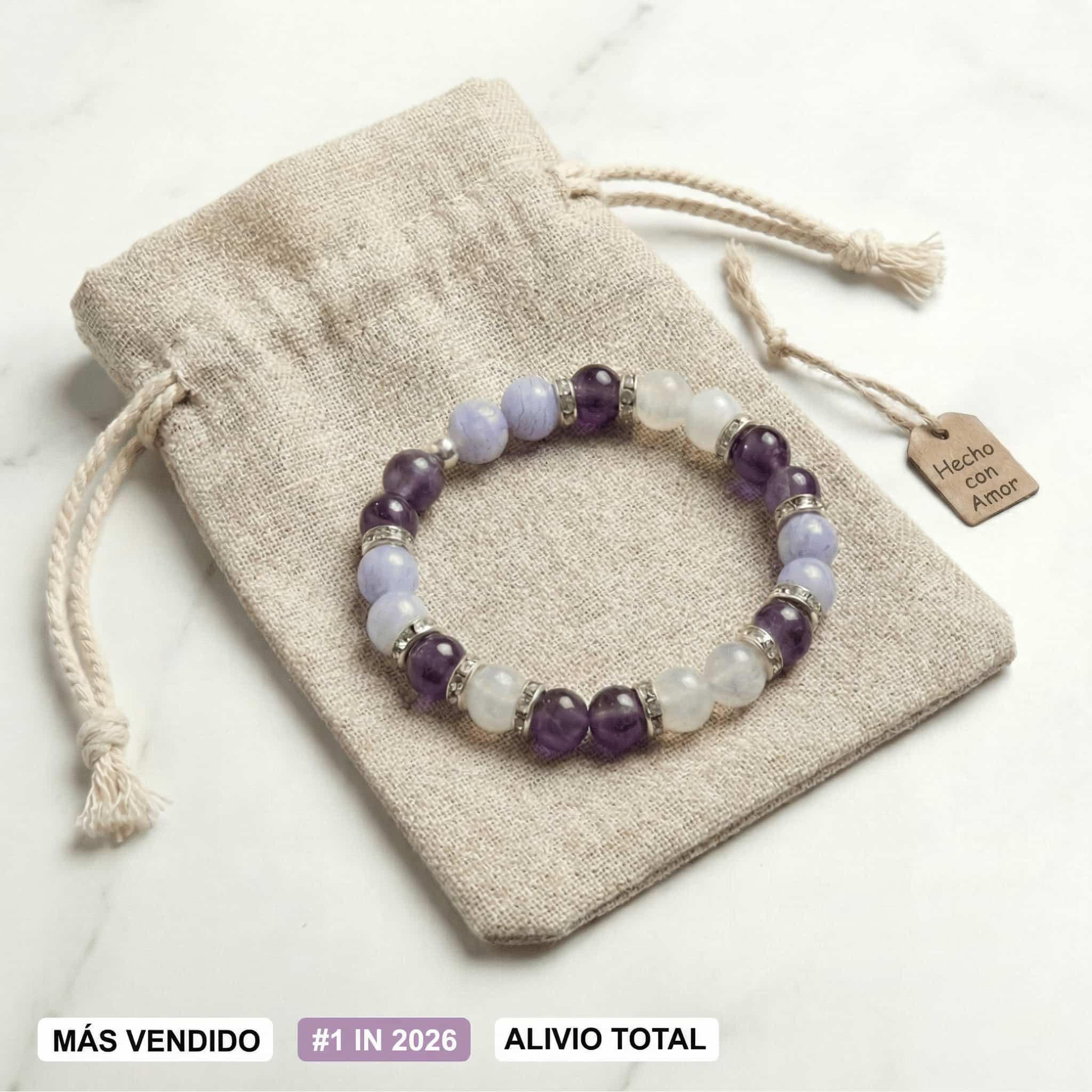 La Pulsera Serena - Alivio natural para la menopausia es una pulsera de piedritas moradas y celestes en bolsa beige con cordón, etiqueta "Hecho con Amor" y sellos: MÁS VENDIDO, #1 EN 2026, ALIVIO TOTAL para menopausia.