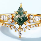 El Set de anillos piedra ágata verde presenta una piedra central en forma de cometa, similar al anillo de ágata musgosa, rodeada por brillantes piedras blancas marquesa y redondas en un diseño elegante y simétrico.