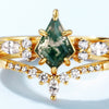 El Set de anillos piedra ágata verde presenta una piedra central en forma de cometa, similar al anillo de ágata musgosa, rodeada por brillantes piedras blancas marquesa y redondas en un diseño elegante y simétrico.