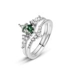 Set de anillos piedra ágata verde: anillo plateado con piedra central en forma de pera, evocando el ágata musgosa, acompañado de pequeños diamantes marquise y redondos, sobre fondo blanco.