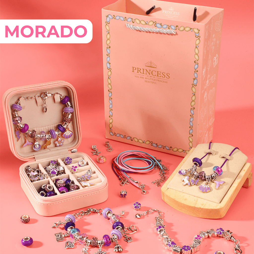 El Set de joyería para crear pulseras y collares + accesorios se muestra con pulseras, dijes y collares en tonos morados, junto a una bolsita de regalo rosa y caja joyero sobre fondo rosado. "MORADO" resalta en letras blancas.