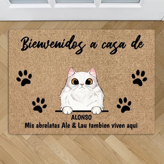 Tapete personalizado Gatos: alfombra antideslizante para mascotas con dibujo de gato blanco, cuatro huellas negras y texto "Bienvenidos a casa de ALONSO. Mis abrelatas Ale & Lau también viven aquí". Ideal para piso de madera.
