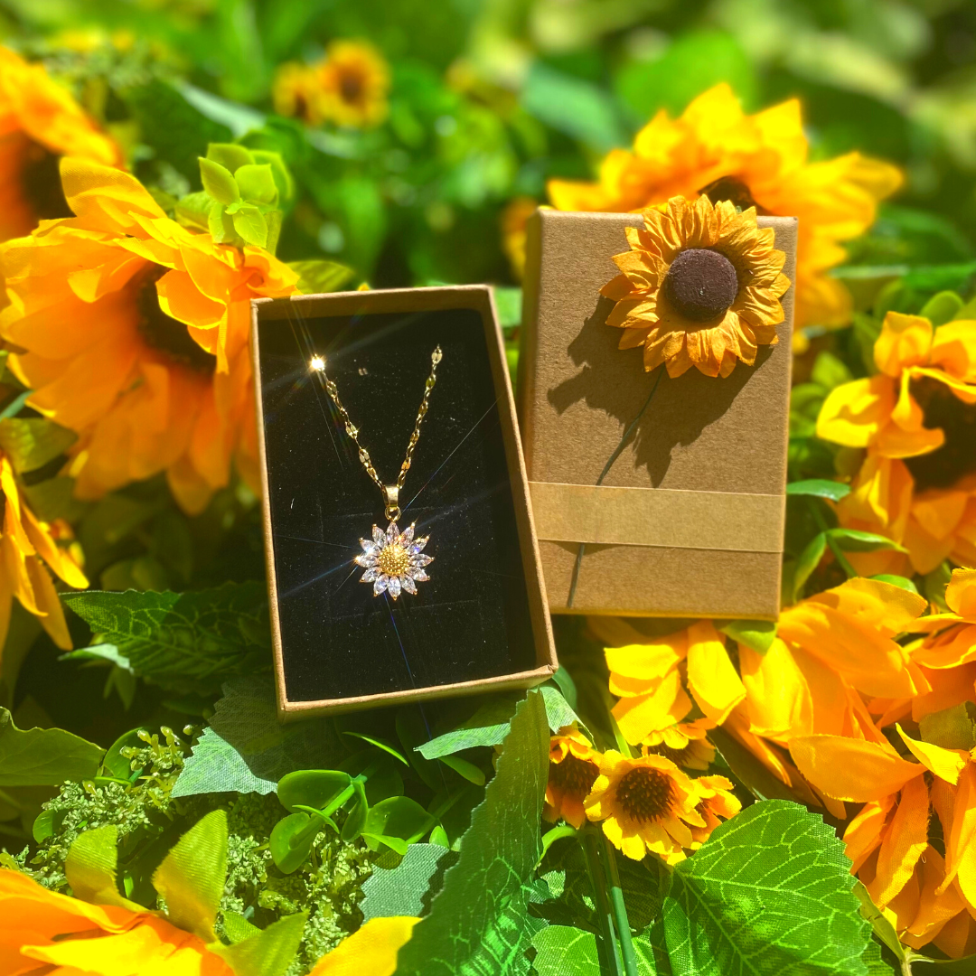 Un collar Tú eres mi sol en una caja adornada con una hermosa flor que simboliza la adoración.